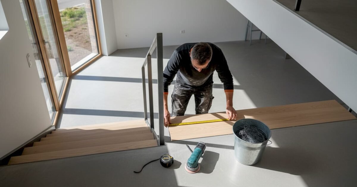 Un professionnel prend les mesures d’une marche d’escalier en acier pour garantir une installation parfaitement adaptée.