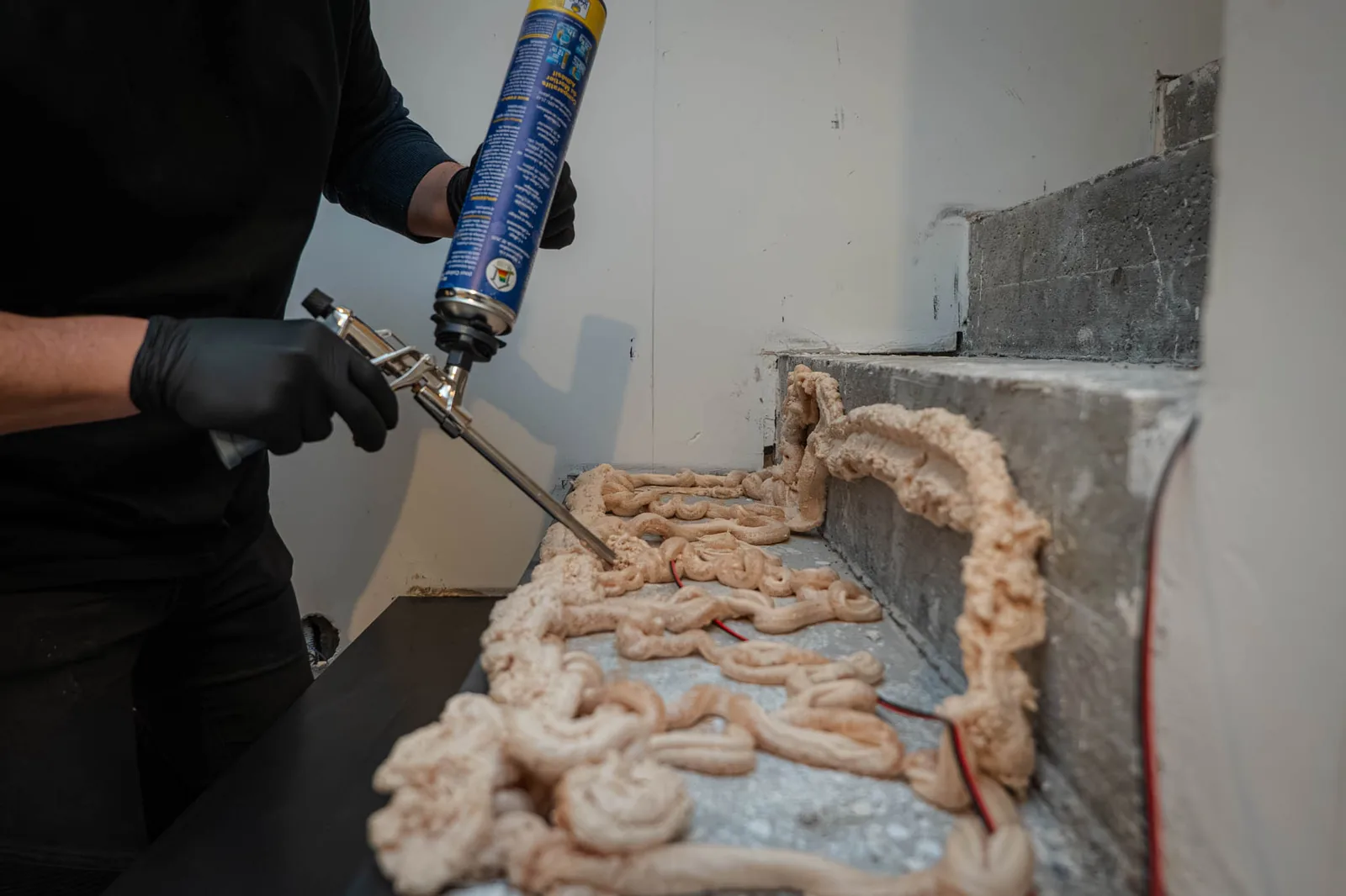 Colle polyuréthane en mousse appliquée au pistolet sur une marche en béton avant la coque