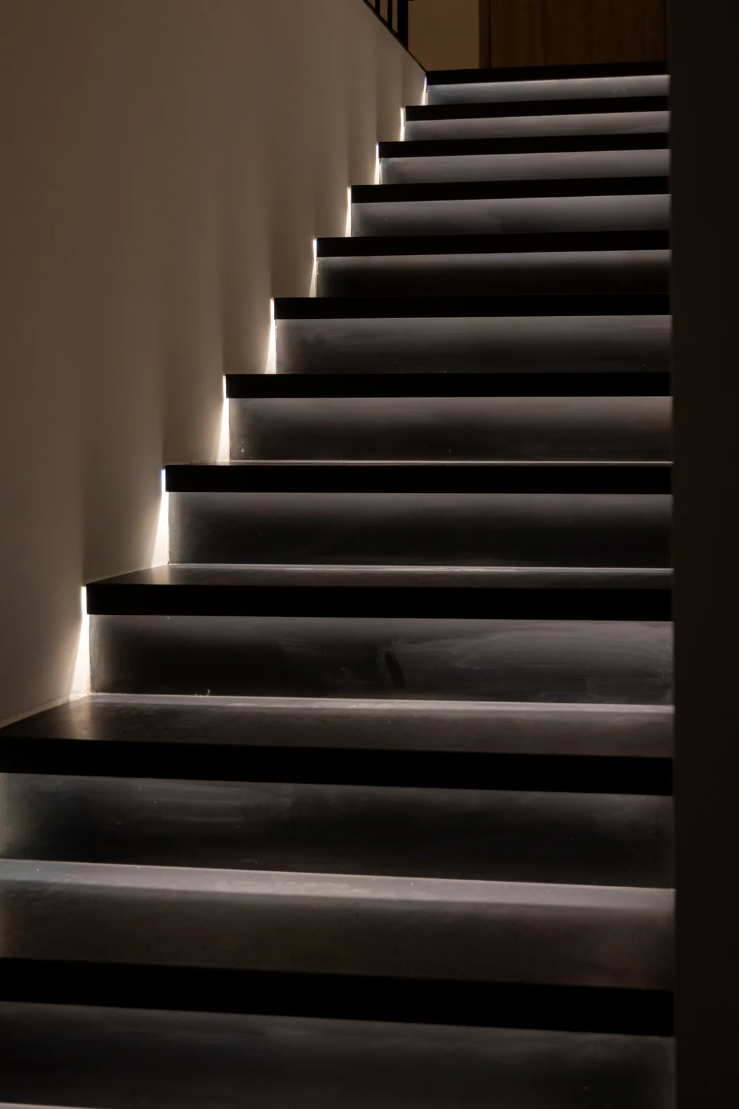 Escalier recouvert d'acier thermolaqué noir de nuit, éclairage LED sous chaque nez de marche
