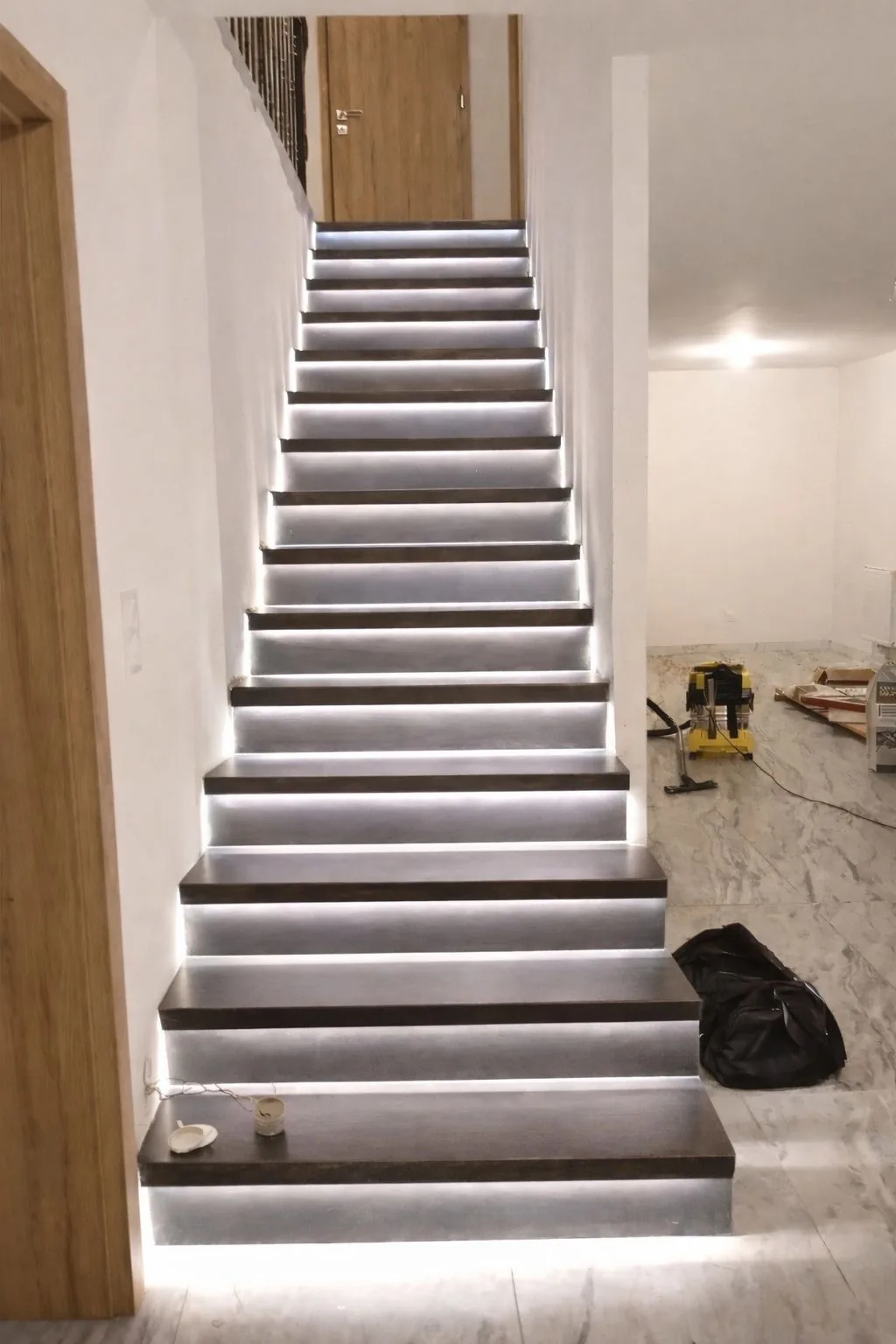 Le même escalier béton après habillage en acier thermolaqué noir, éclairage LED ajouté par le client
